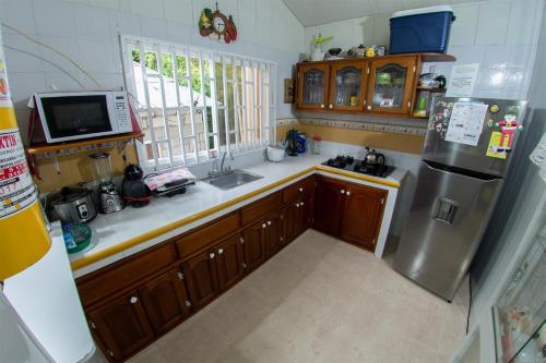 a kitchen with a sink and a refrigerator at Posada Nativa Atardecer Isleño in San Andrés
