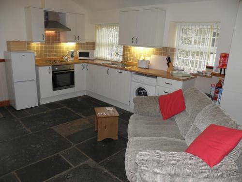 a living room with a couch and a kitchen at OLD BAKEHOUSE in Holmrook