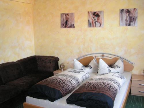 a bedroom with a bed with pillows and a couch at Hotel Sternen in Lenzkirch