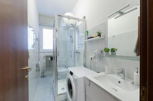 uma casa de banho com uma máquina de lavar roupa e um lavatório em Appartamento moderno San Siro em Milão