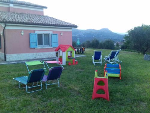 a group of chairs sitting in the grass in a yard at La Masseria di Villa Giulia in Tocco da Casauria
