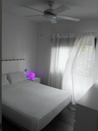 a white bedroom with a bed and a ceiling fan at Casa Playa Puerto Mazarrón in Puerto de Mazarrón