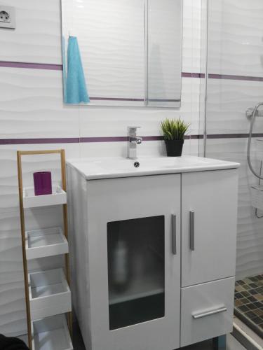 a white bathroom with a sink and a mirror at Casa Playa Puerto Mazarrón in Puerto de Mazarrón