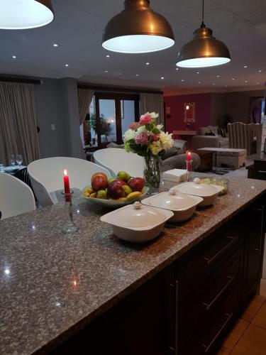 a counter with bowls of fruit and candles on it at Dinaledi House in Bela-Bela