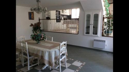 a dining room with a table with a vase of flowers on it at duplex house un center village in Campeã