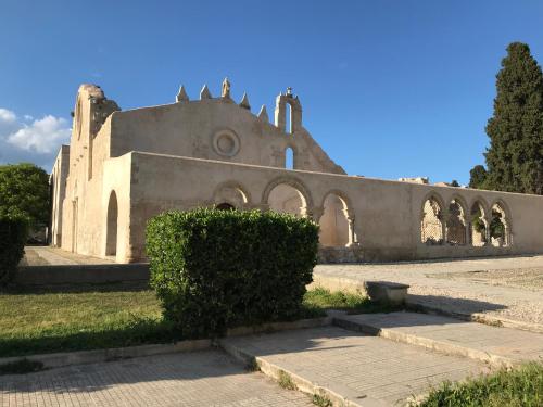 an old building with some bushes in front of it at Il Tempio di Athena - Cultura e Relax a Siracusa in Siracusa