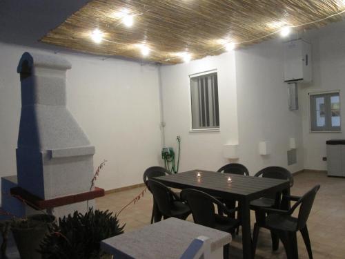 a dining room with a table and chairs and a stove at Maison Gigante in San Donato di Lecce