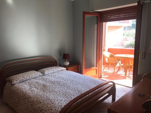 a bedroom with a bed and a patio with a table at Casa vacanza borgo marinaro Santa Tecla complesso Le Sirene in Acireale