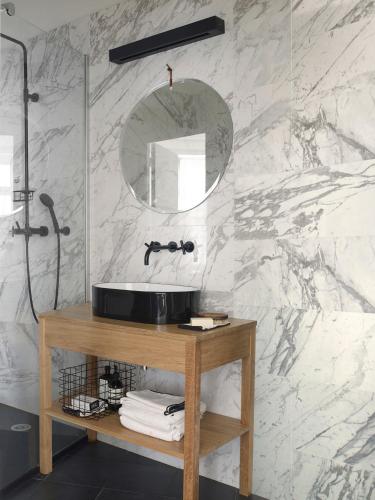 une salle de bain avec un lavabo et un miroir dans l'établissement Une Suite A Vannes, à Vannes