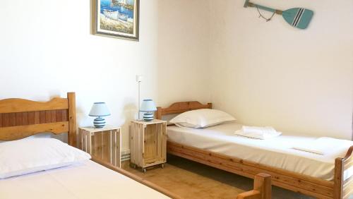 two twin beds in a room with two lamps at Anemos Seaside House in Skiros