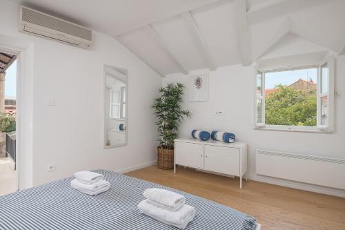 une chambre blanche avec un lit et une fenêtre dans l'établissement Apartments Olaf, à Dubrovnik