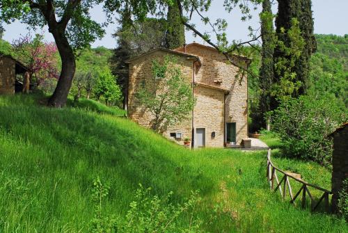an old stone house on a grassy hill at La Doccia in Anghiari