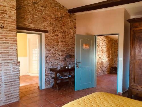 a bedroom with a blue door in a brick wall at La Vieille Demeure in Torreilles