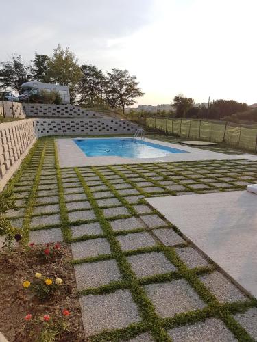a swimming pool in a yard next to a garden at Agriturismo bio Verde Armonia in Montemarciano