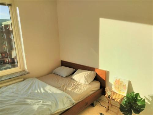 a small bedroom with a bed and a window at Cozy room in hip central area in Gothenburg