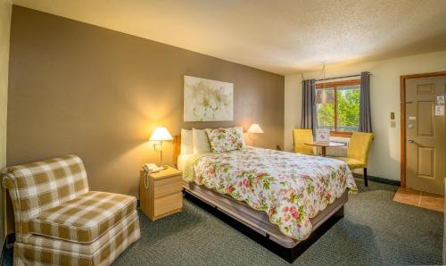 ein Schlafzimmer mit einem Bett und einem Stuhl in der Unterkunft Ephraim Motel in Ephraim