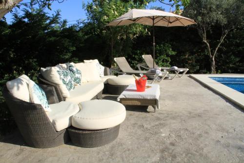 a group of chairs and an umbrella next to a pool at Masia Can Magan Lux, Ideal Grupos 20pax in Palafolls