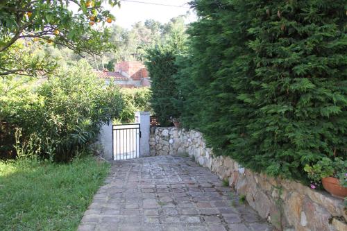 a stone path next to a stone wall with a gate at Masia Can Magan Lux, Ideal Grupos 20pax in Palafolls