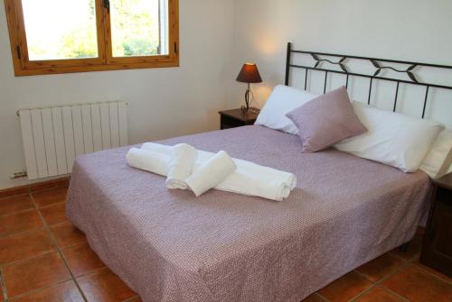 a bed with two white towels on top of it at Masia Can Magan Lux, Ideal Grupos 20pax in Palafolls