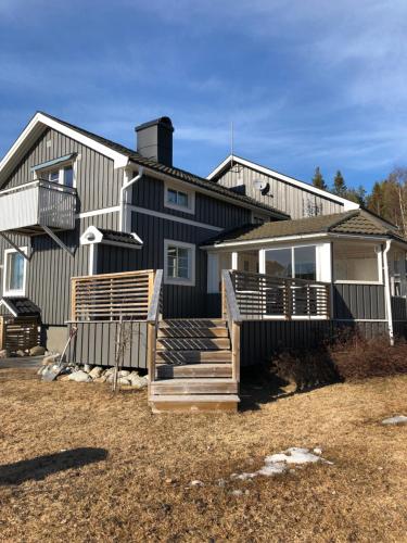 Una casa grande con porche y escaleras delante. en Villa utanför Örnsköldsvik, Höga Kusten en Örnsköldsvik