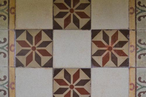 a tiled bathroom floor with brown and white tiles at B&B Le Macine 1868 in Paceco