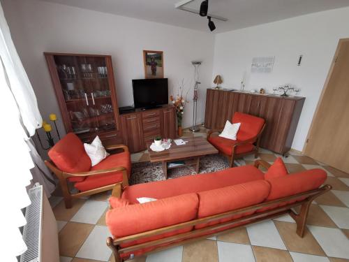 uma sala de estar com um sofá e duas cadeiras e uma mesa em Ferienwohnung "Wißbergblick" em Wolfsheim
