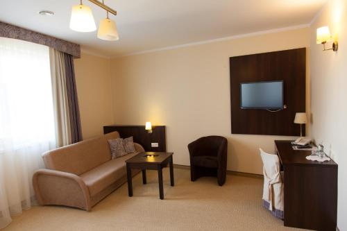 a hotel room with a couch and a tv at Hotel Ostrawa in Wodzisław Śląski