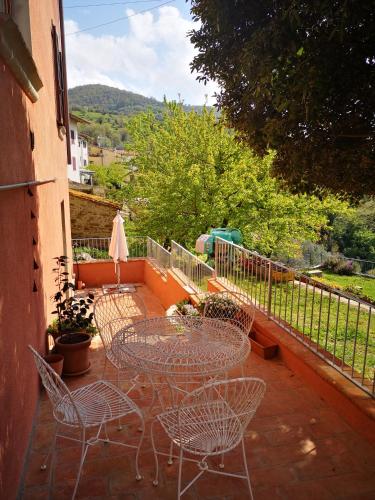a patio with chairs and tables on a balcony at La Casa Rosa in Polveraia