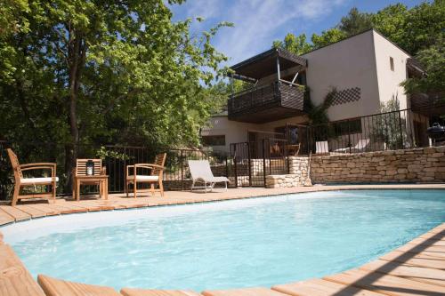 une piscine avec des chaises et une maison dans l'établissement La Source, à Saint-Saturnin-lès-Apt