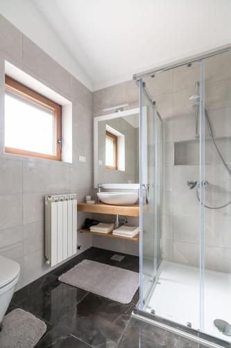 a bathroom with a glass shower and a sink at Apartments Norma in Funtana