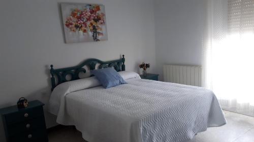 a bedroom with a bed with a blue pillow on it at VILLA MARIA in Vilches