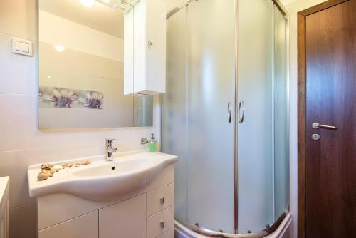 a bathroom with a sink and a shower at Apartments CAPE Deluxe in Rtina