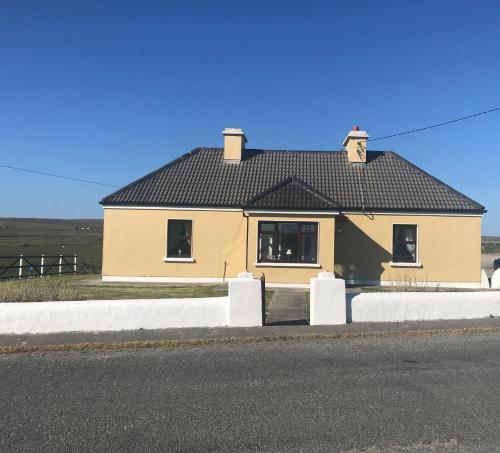 a yellow house on the side of a road at The West House in Belmullet