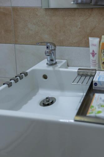 a white sink with a faucet in a bathroom at Studio Jasna in Novi Sad