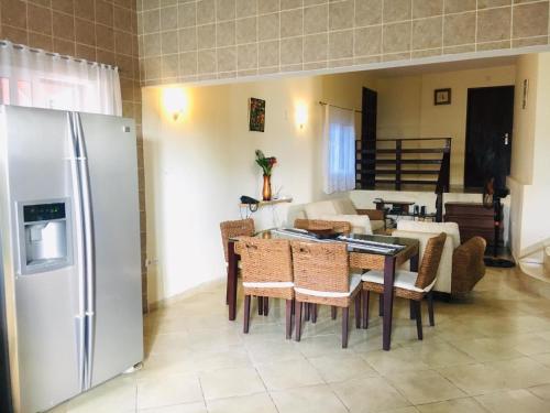 eine Küche und ein Esszimmer mit einem Tisch und einem Kühlschrank in der Unterkunft casa Luis in São Tomé
