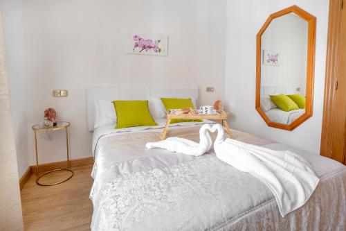 sypialnia z łóżkiem z lustrem i stołem w obiekcie Apartamento Candela w Salamance