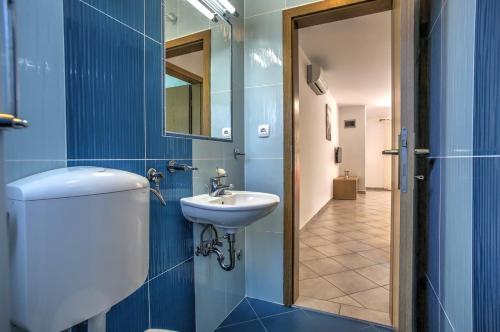 W łazience znajduje się toaleta, umywalka i lustro. w obiekcie Apartment Ena 3 w mieście Betina