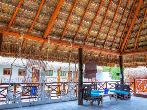 a patio area with chairs, tables and umbrellas at Hacienda Dos Ojos in Tulum