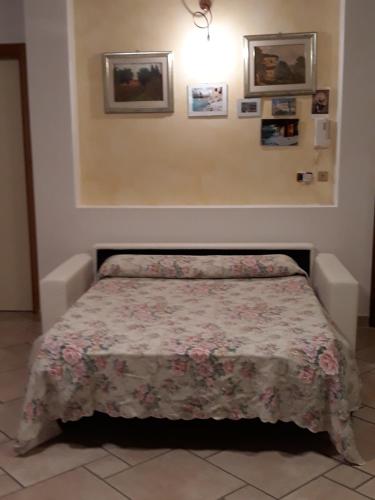 a bedroom with a bed with a floral bedspread at Il Giardino degli Ulivi in Rapolano Terme
