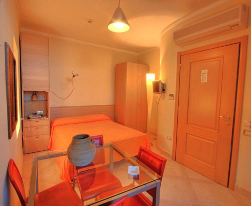 a small room with a bed and a glass table at Posidonia Residence in Ischia
