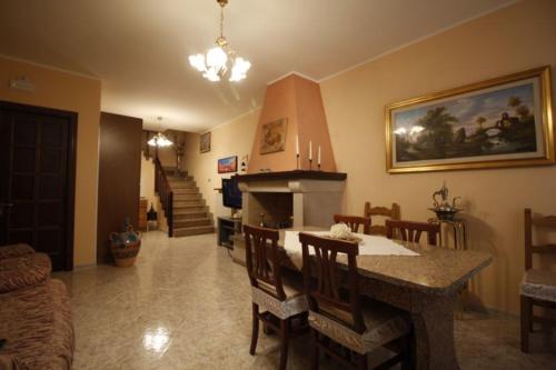 sala de estar con mesa con sillas y chimenea en Affittacamere San Lorenzo, en Norcia