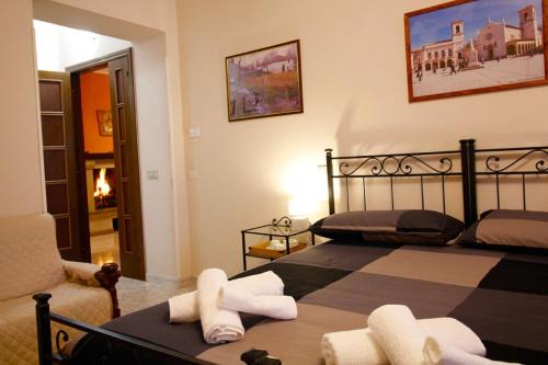a bedroom with two beds and a chair at Affittacamere San Lorenzo in Norcia