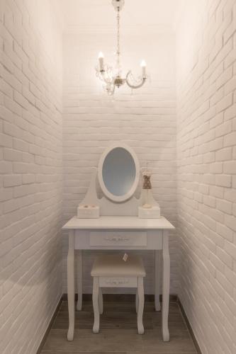 a white dressing table with a mirror and a chandelier at Olympus Studios in Malia