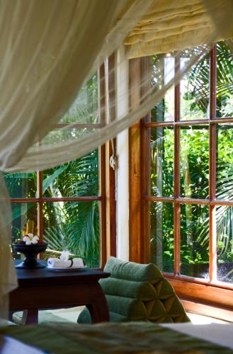 a bedroom with a green couch and a large window at The Damai in Lovina