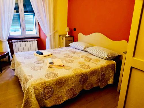 a bedroom with a bed with a yellow and orange wall at LA CASA DI NONNO GINO in Levanto