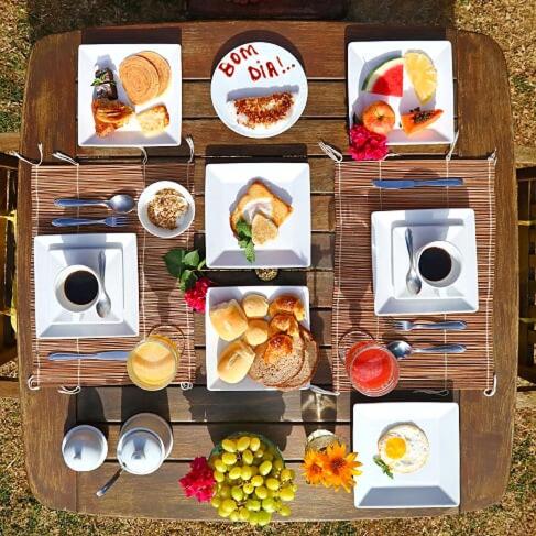 ein Tisch mit vielen Tellern voller Essen in der Unterkunft Pousada Ilha do Frade in Fernando de Noronha
