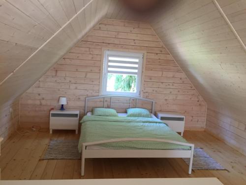 a bedroom with a bed in a attic at Świerkowy Zakątek in Sztutowo
