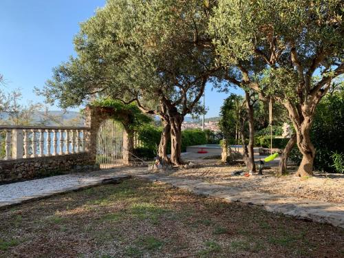 un grupo de árboles con una valla y una puerta en Apartments Villa Julia, en Trogir
