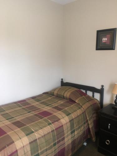 ein Schlafzimmer mit einem Bett mit einer karierten Decke in der Unterkunft The Country Inn Motel in Gander