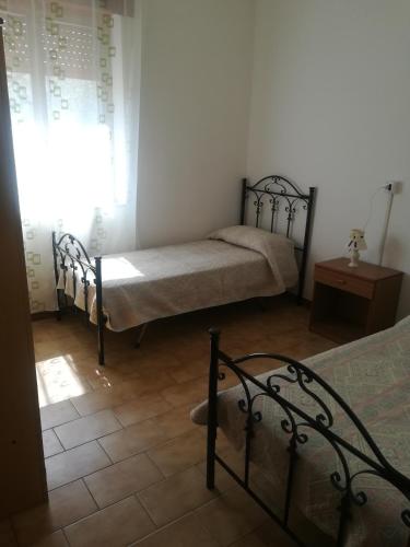 1 dormitorio con 2 camas y ventana en Appartamento Sole e Mare, en Palinuro